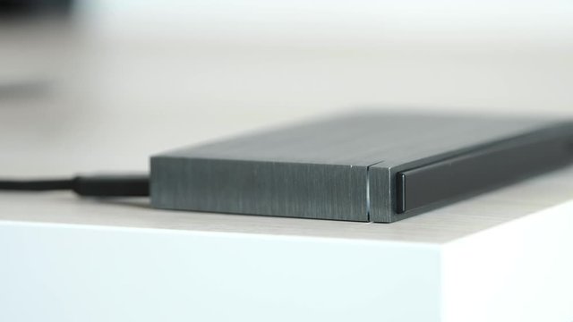 External Hard Drive On a Table, Led Light Flickering - Solid Aluminium Casing HDD, Minimalist Design Composition - Macro Closeup