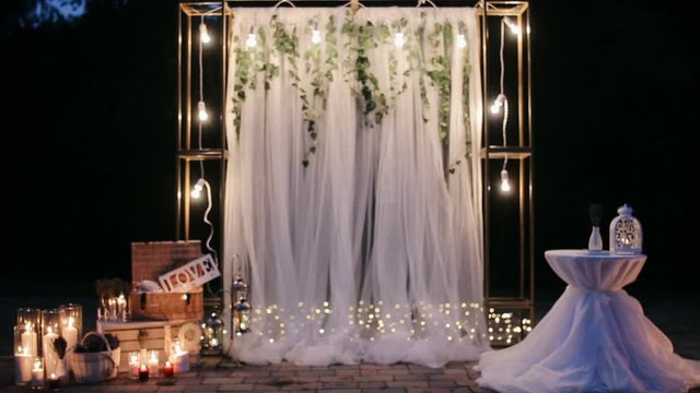 Wedding ceremony decoration with candles at night outdoors