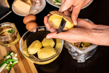 I peel potatoes by hand. The process of making potato pancakes