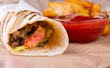 Rolls with vegetables and meat in lavash, served with fries and ketchup potatoes