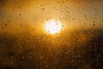 Sunset warm light through the wet window after rain 