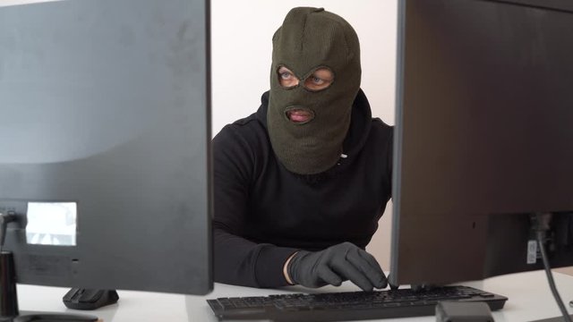 Young hacker in the dark breaks the access to steal information and infect computers and systems.