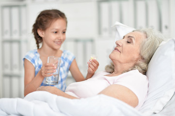 Portrait of granddaughter with grandmother sitting at home
