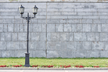 vintage lightpost near the grey wall and green grass