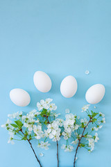 White eggs on blue background with flowers