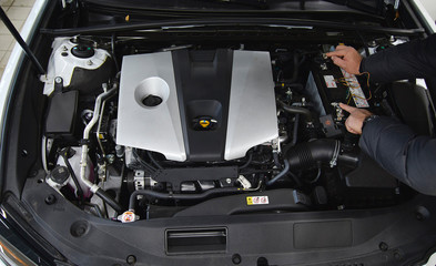 mechanic checking the voltage of a battery using a voltmeter