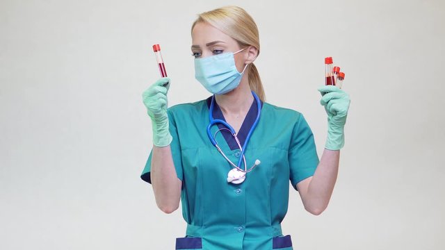 medical doctor nurse woman wearing protective mask and latex gloves - holding blood test tube