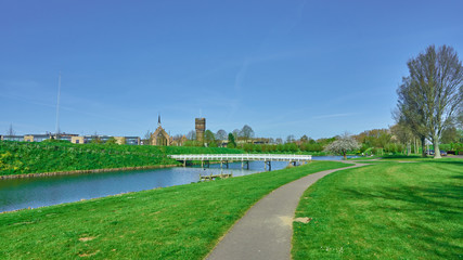Fototapeta premium Church and military tower behind the river in old town. Hellevoetsluis. Holland