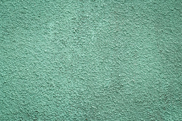 Green painted concrete wall. Texture of plaster, stucco. Grunge stone background, whitewash wallpaper.