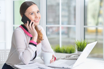 Portrait of young beautiful woman working at table