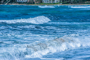 A fresh spring wind drives the waves to the coast of Cyprus. The Mediterranean Sea is painted with dark ultramarine and a luminous azure from the inside.     
