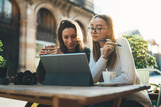girls drink coffee relax in cafe outdoor in europe city. Freelancer communicate on project, girls shopping online on wifi tablet. Students studies on internet. Working business process