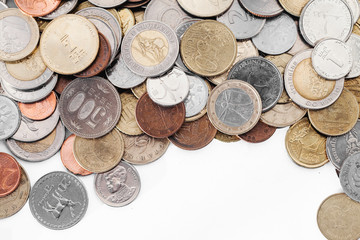 Different currency coins stacked. Pile of money. Financial world background. Empty copy space isolated on white. Janapese yen, Israeli shekel and others.