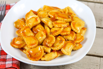 assiette de raviolis à la sauce tomate sur une table en bois