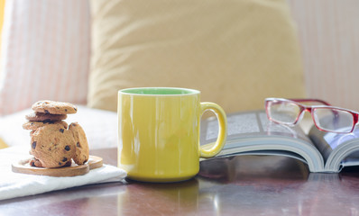 Hot coffee with cookies and books on a wooden table The idea of ​​resting at home