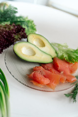 Avocado with red fish and lettuce - healthy breakfast	