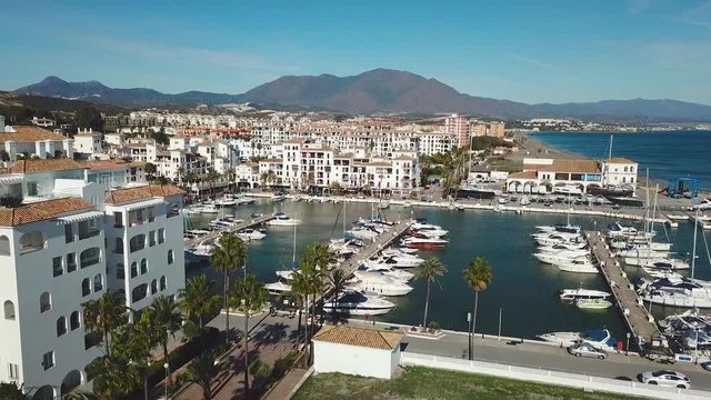 MANILVA, MALAGA / Spain - December 14 2019: Beautiful Aerial panoramic view of "Puerto de la Duquesa". Yachts and boats docked in the Harbour. Luxury Apartment Urbanisation, Restaurants. Pedestal down