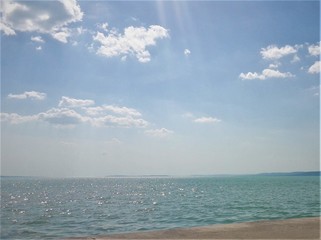 blask promieni słońca odbijających się w wodzie na tle  błękitnego nieba © Robet