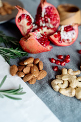Pomegranate fruit, walnuts, cashew nuts on the table - healthy food products