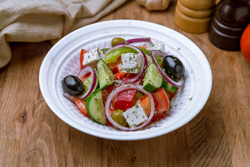 Greek salad with feta on wooden table
