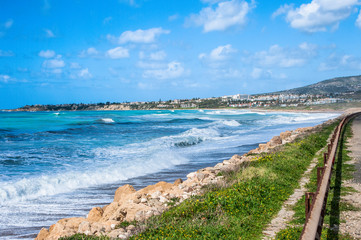 A fresh spring wind drives the waves to the coast of Cyprus. The Mediterranean Sea is painted with dark ultramarine and a luminous azure from the inside.     