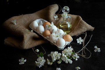 nine white and yellow eggs in a box with flowers on a black background