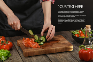 Woman cooking fresh healthy salad. Female hands cutting vegetables on board on wooden table with sample text.