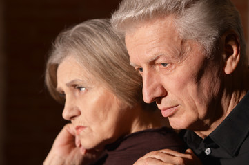 Portrait of sad senior couple posing at home