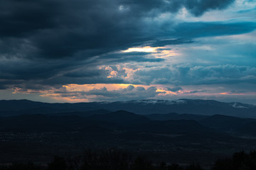 Ciel très menaçant pendant le coucher du soleil au dessus du Mont Lozère enneigé et des montagnes des Cévennes (Occitanie, France)