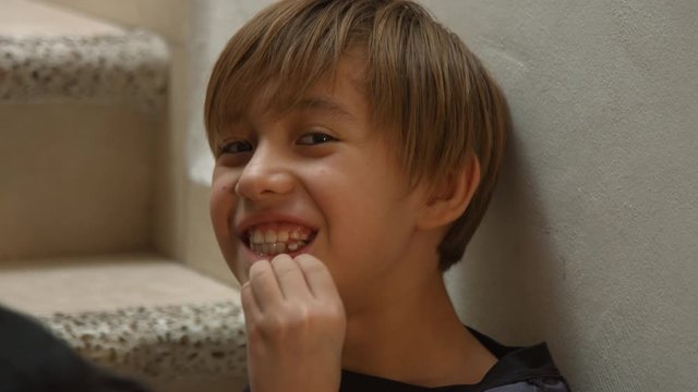 Naughty boy, shows his tooth about to fall out, showing loose tooth