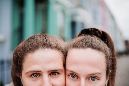 Extreme close up portrait of the faces of two young white girls with clear eyes. 
