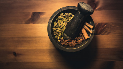 High angle view of the Christmas spice mix in the bowl with mortar and pestle on the wooden kitchen table