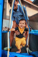 Toddler boy enjoying playing on the trampoline