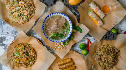 Assorted asian dinner, vietnamese food. Pho ga, pho bo, noodles, spring rolls top view