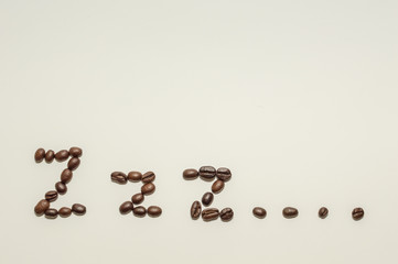 Coffee beans spelling out the word "Zzz" against a white background