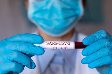 Test tube with blood coronavirus test in doctor’s hands , closeup view 