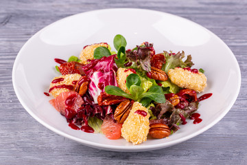 Salad with chicken fillet in bread crumbs, served with pecan nuts and fresh salad