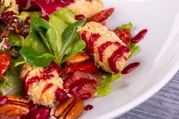 Salad with chicken fillet in bread crumbs, served with pecan nuts and fresh salad