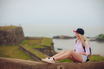 Beautiful young girl tourist woman in a hat on the background of the historical center of Galle...