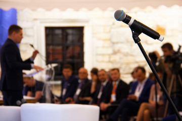 Zbarazh, Ternopil region, Ukraine - 05.24.2018: Investment Forum "Ternopil region Invest-2018" at Zbarazh castle: microphone on the background of a businessman who speaks to the audience on stage.