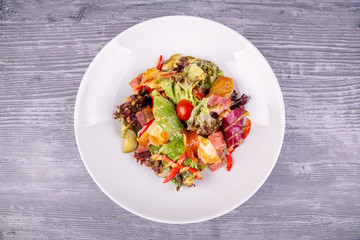 Salad with bacon, pickles, cherry tomatoes, sweet pepper and mustard sauce