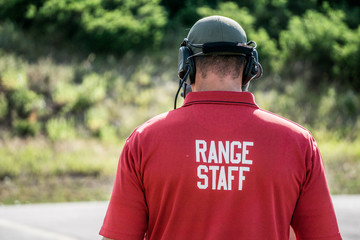 A range safety officer walks on a gun range during a police firearms training day. - obrazy, fototapety, plakaty