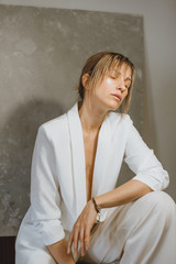 Sensual portrait of a young attractive woman in a white blazer.