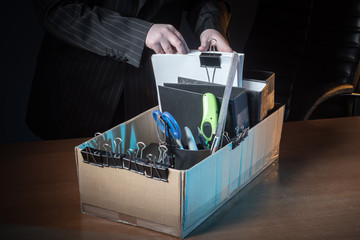 A cardboard box with things from the workplace. The person leaves the workplace. Dismissal. The...