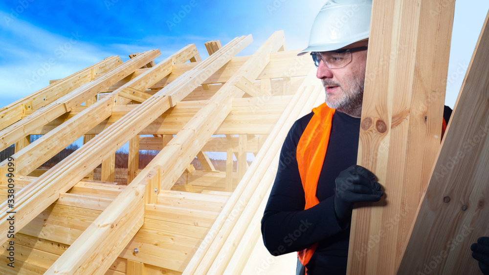 Aufkleber installation of the roof of the cottage. builder with boards on the background of the frame of a new