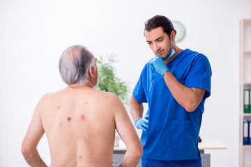 Old man visiting young male doctor dermatologist