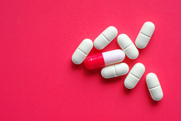 high angle view of white pills and capsule on color background 