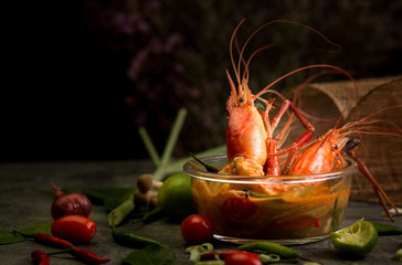 Thai food, Tom Yam Kung in bowl with ingredients on table