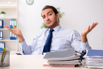 Young male businessman employee unhappy with excessive work