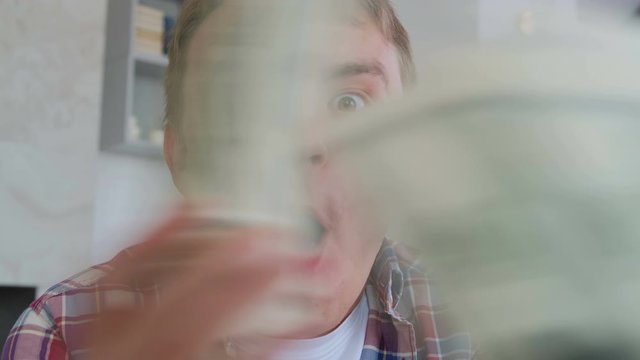 Happy young successful man with money in his hands in dollars rejoices. Emotions of delight and happiness